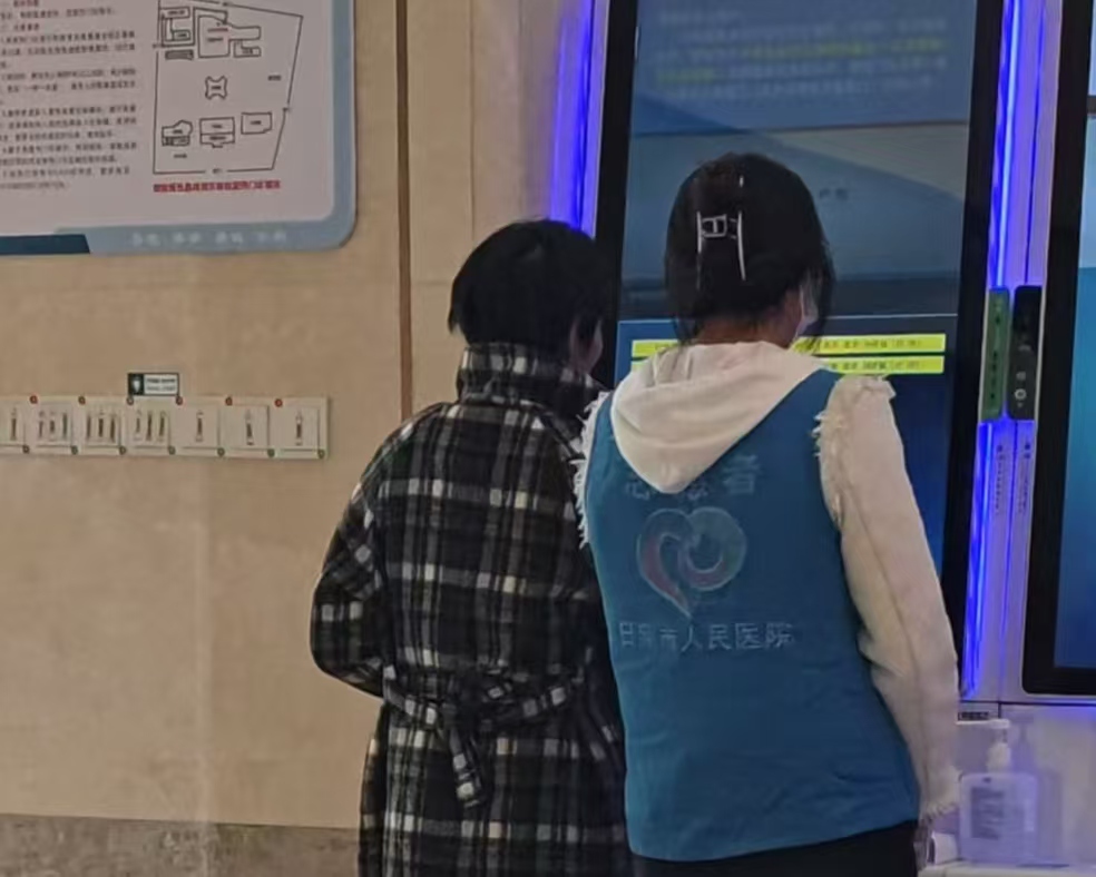 圖為志愿者在自助掛號機為患者服務  邱安琪供圖
